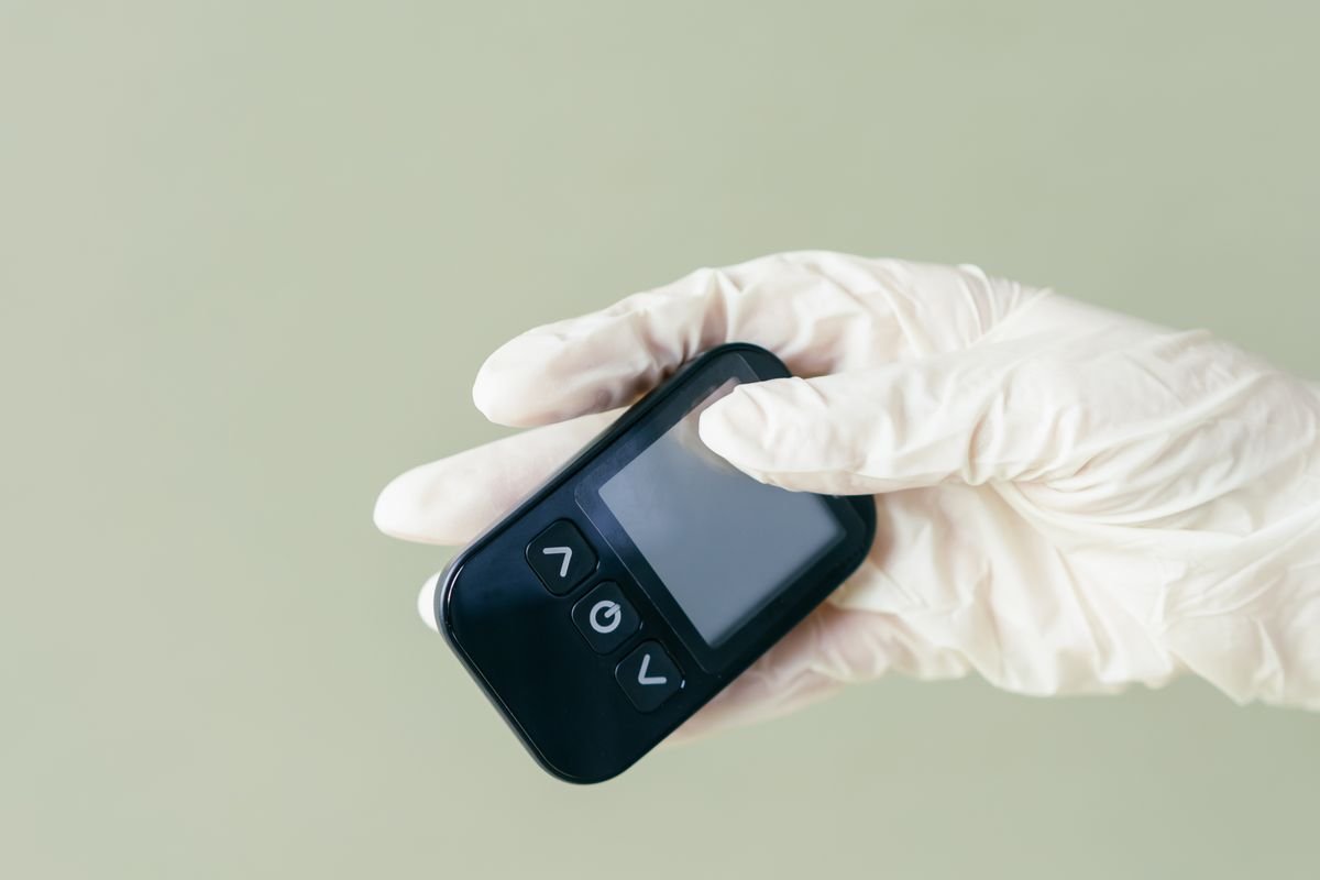 Healthcare worker holding a blood glucose meter